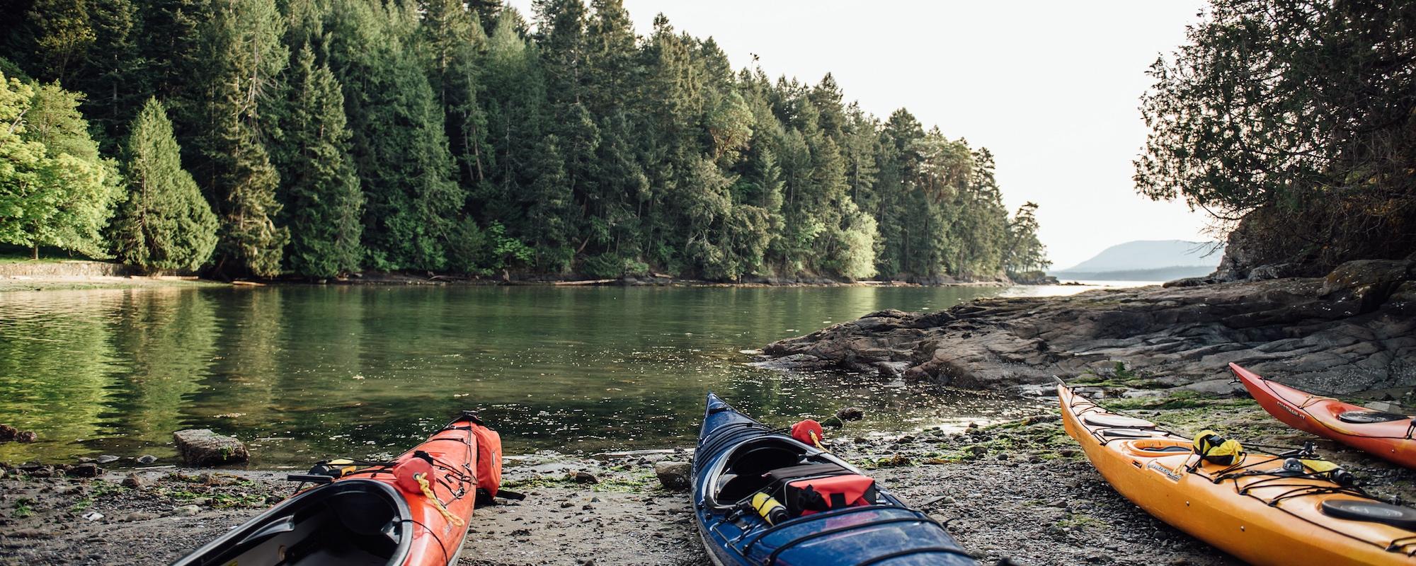 kayaks on the southern gulf islands' shore belonging to  Pender Island Kayak Adventures